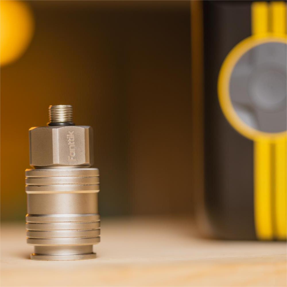 Fanttik S08 female industrial air coupler with ribbed design, on a table with blurred background.