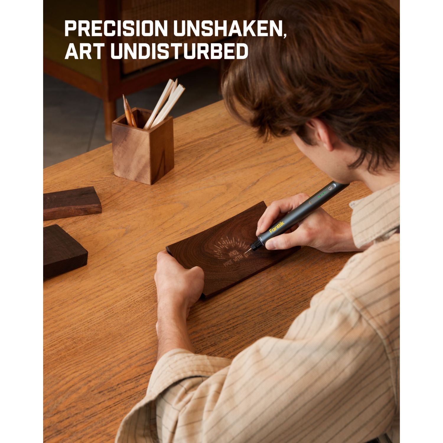 Person engraving wood with Fanttik F2 Master cordless rotary tool, precision art on table