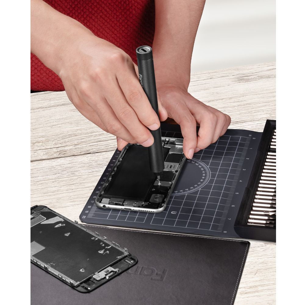 Fanttik E1 NEX electric screwdriver being used for smartphone repair with 64 precision bits and workstation mat.