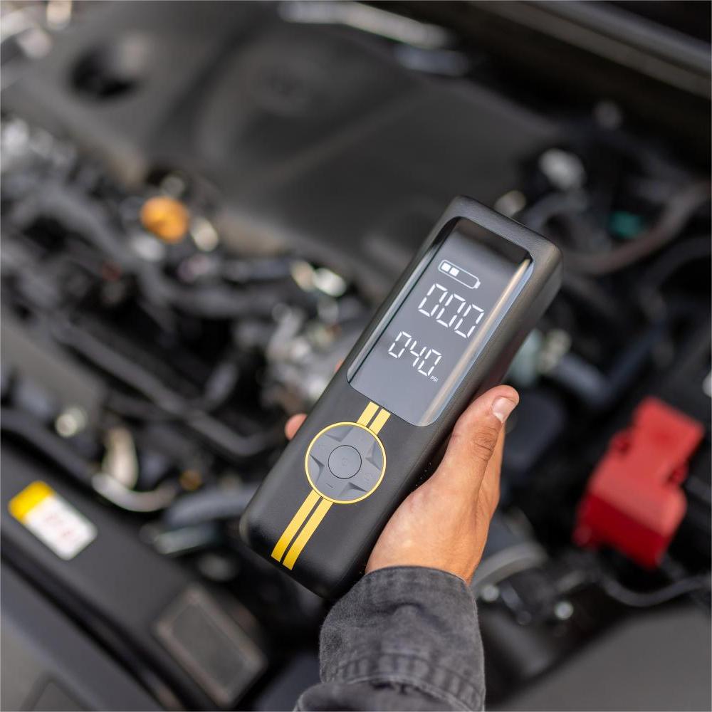 Fanttik X8 APEX tire inflator with 040 PSI display held near car engine