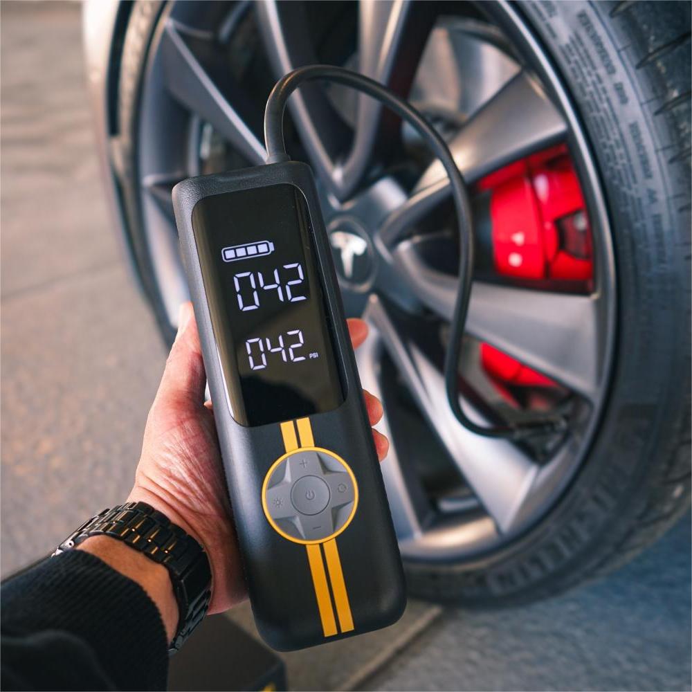 Fanttik X8 APEX EV tire inflator showing 042 PSI beside a car wheel