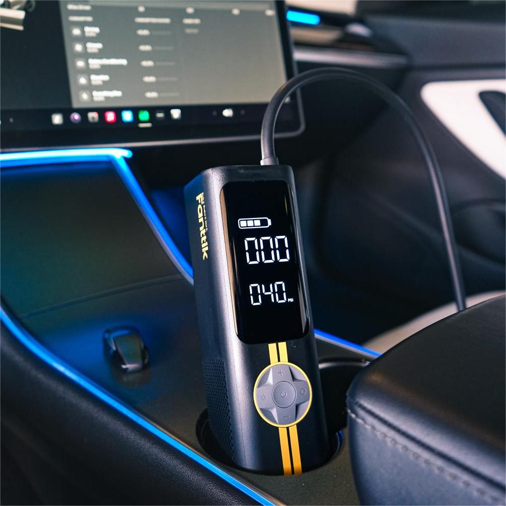 Fanttik X8 APEX EV tire inflator in a Tesla center console, digital display and hose attached