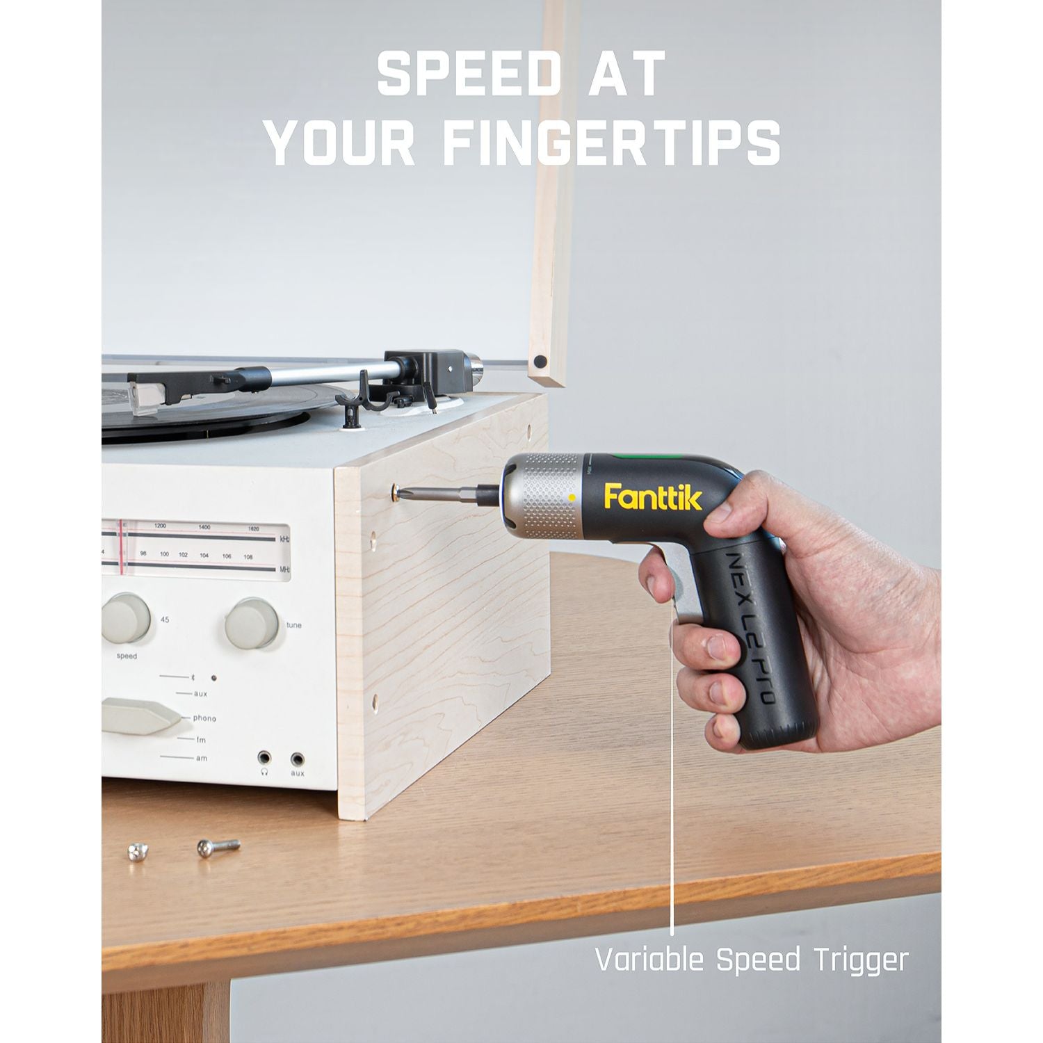 Fanttik L2 Pro cordless screwdriver with variable speed trigger, used on wood furniture. Features yellow logo.