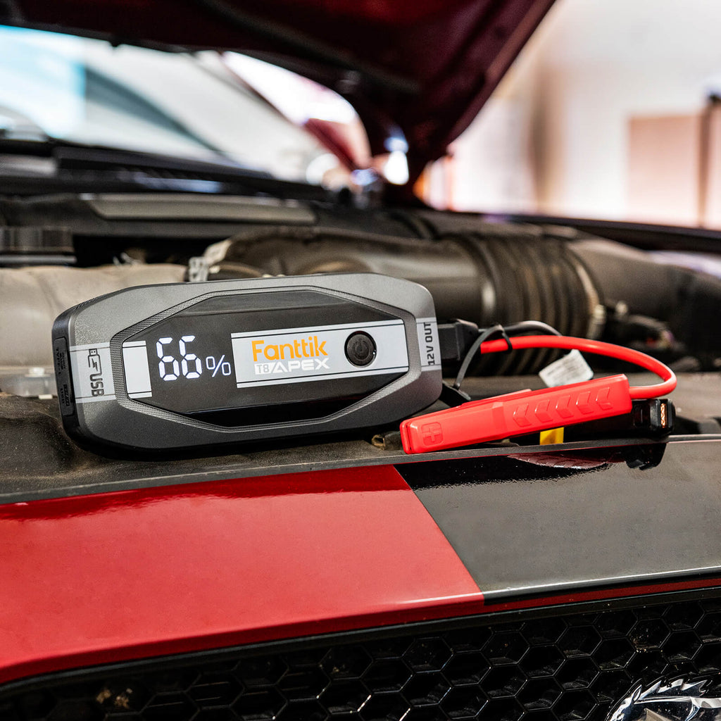 Fanttik T8 APEX 2000 Amp Jump Starter with 66% battery, connected to car engine for jump start.