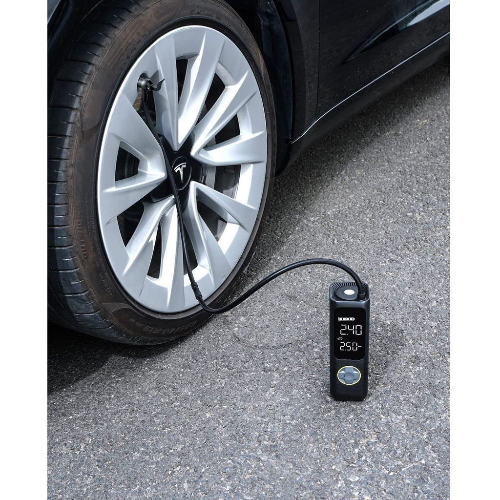 Fanttik air pump extension hose adapter connected to Tesla car tire, displaying 240 and 250 PSI on its digital screen.