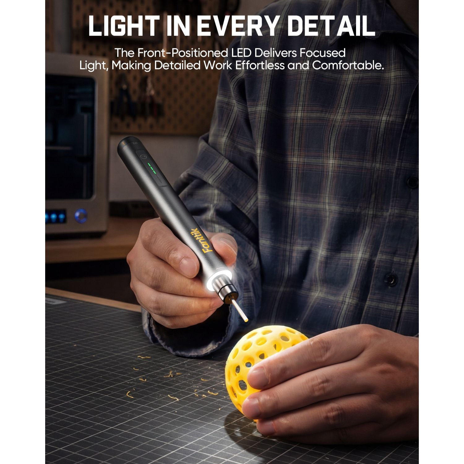 Cordless rotary tool with front LED light carving a yellow 3D model