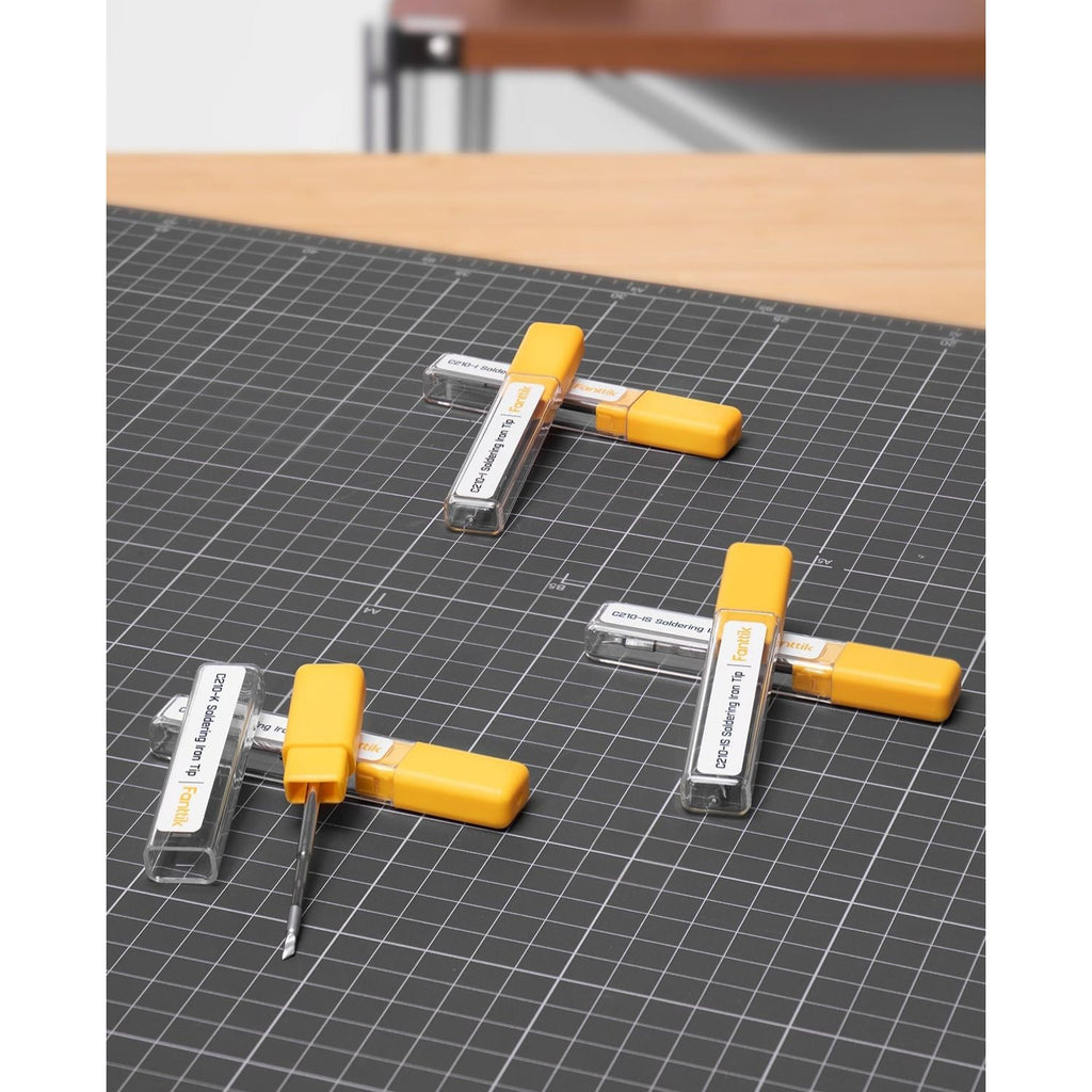 Fanttik C210 soldering iron tips in yellow cases on a cutting mat