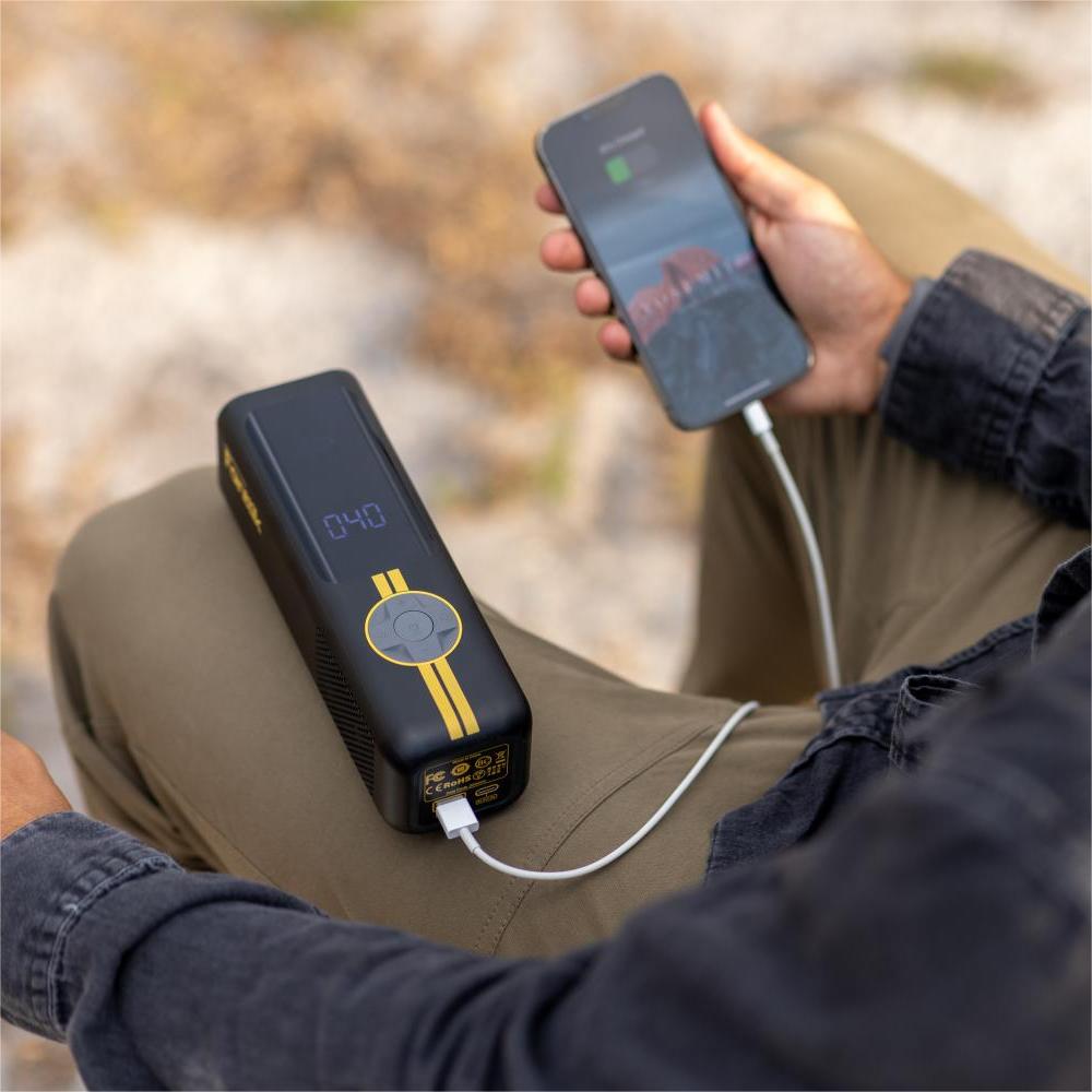 Fanttik X8 APEX tire inflator charging smartphone, showing 040 PSI and power bank functionality.